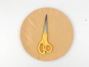 cut circle out of brown paper for pizza crust