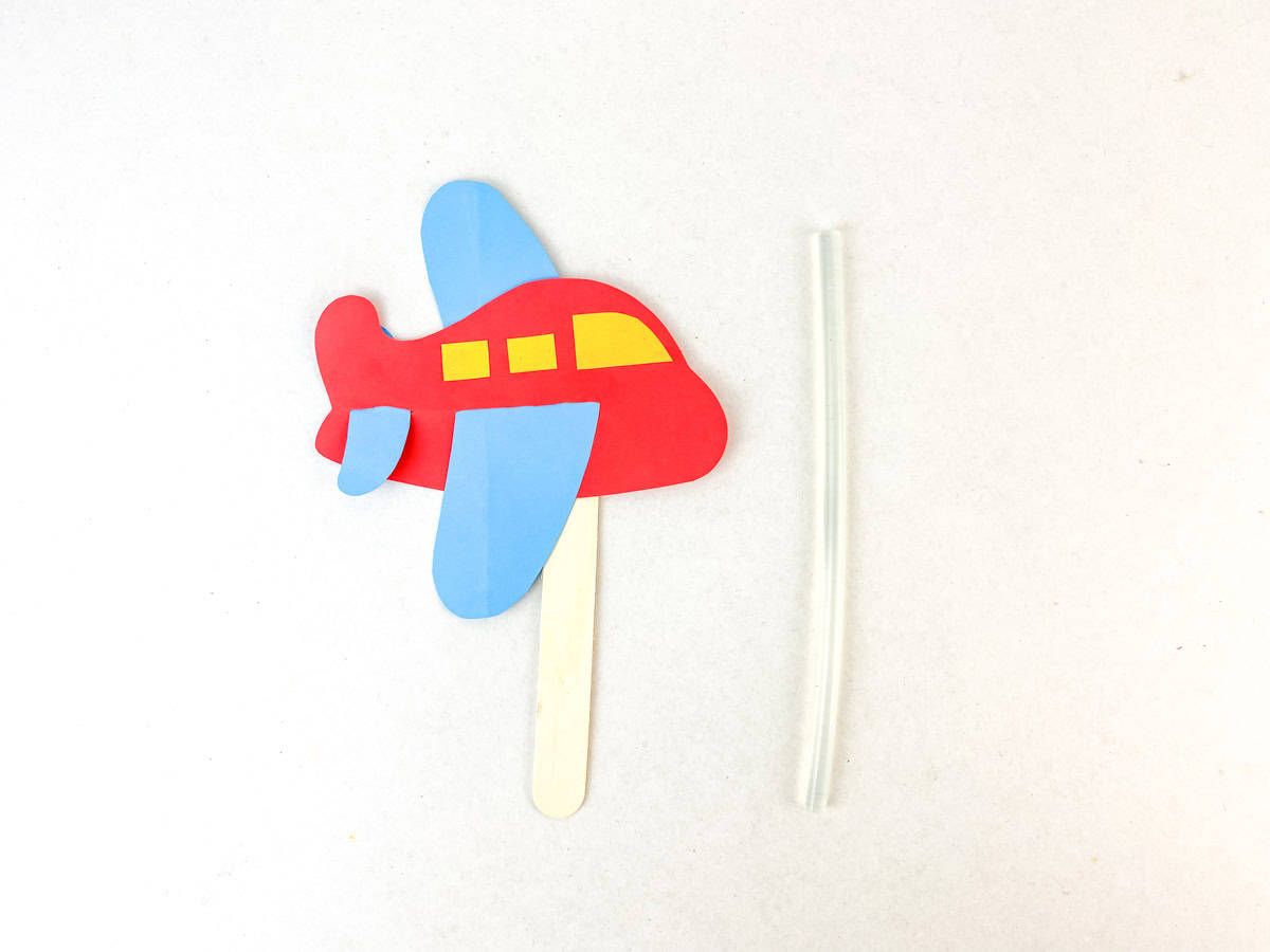 glue craft stick to back of paper airplane craft