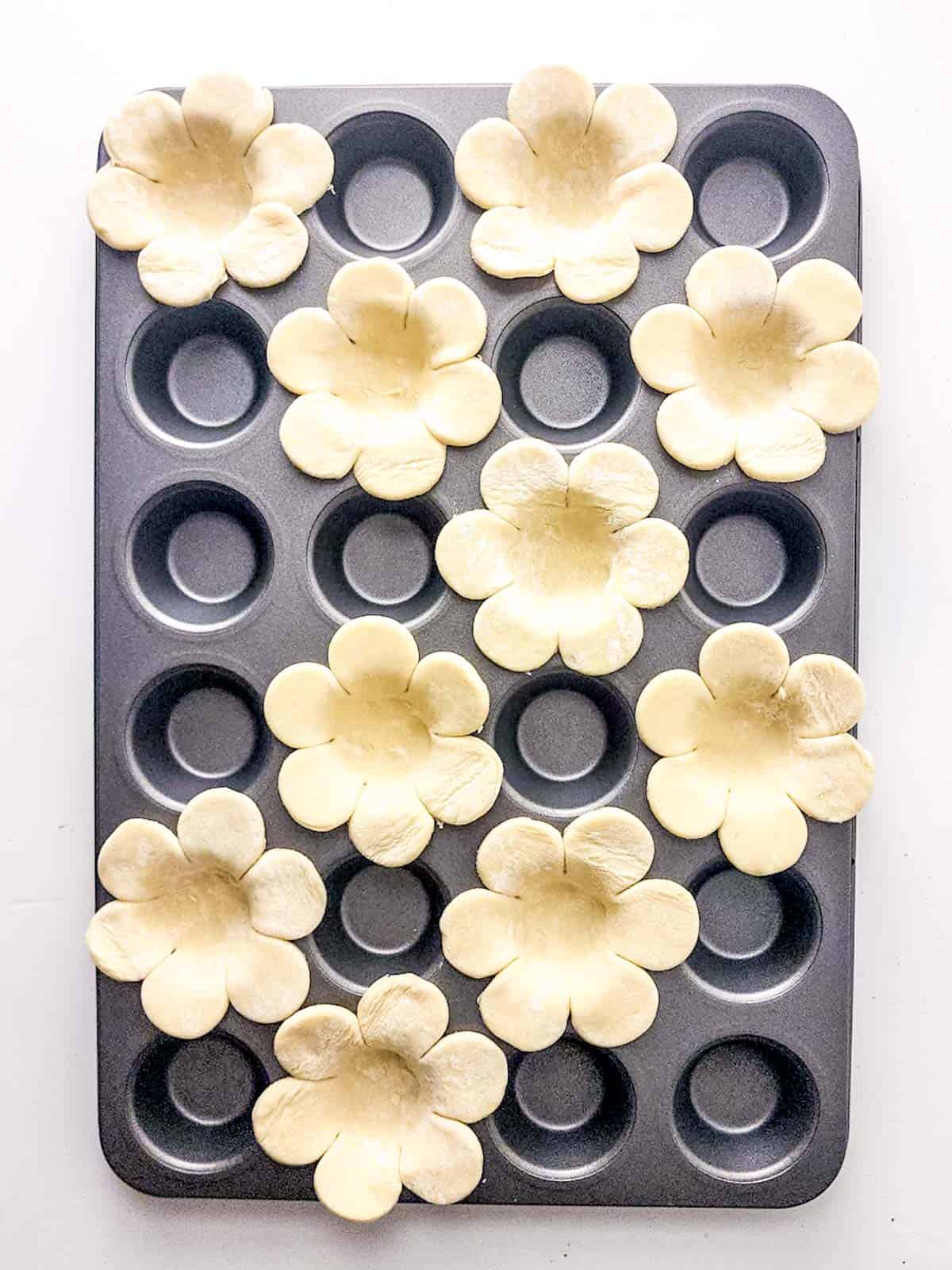 place puff pastry flowers into mini cupcakes